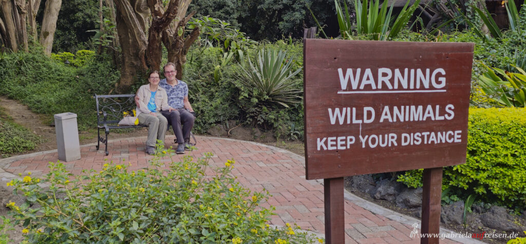 couple-sitting-behind-a-sign